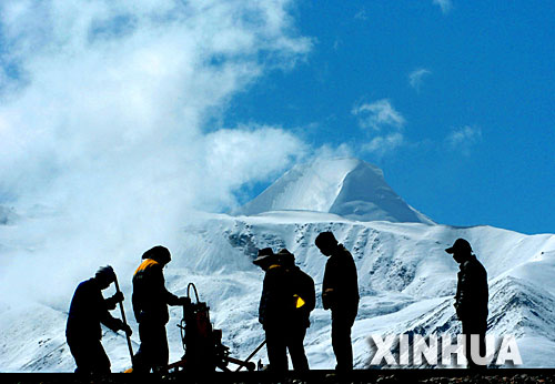 青藏鐵路建設者在西藏桑典康桑雪山腳下整道(2005年6月8日攝)。 青藏鐵路從西寧至拉薩全長1956公里,是世界上海拔最高、線路最長、穿越凍土里程最長的高原鐵路。把鐵路修進西藏是幾代中國人的夢想,但這一想法直到新中國成立后才逐漸變為現實。青藏鐵路一期工程西寧至格爾木段于1958年開工,1984年交付營運。但限于當時國家的經濟實力以及高原、凍土等筑路技術難題尚未解決,格爾木至拉薩段被迫停建。2001年6月,國家總投資330.9億元動工修建青藏鐵路二期工程。這一工程跨越昆侖山、唐古拉山,通過多年凍土層和大片“生命禁區”,是人類鐵路建設史上亙古未有的穿越。它的建成將為神秘而古老的青藏高原帶來新的生機和活力! 新華社發
